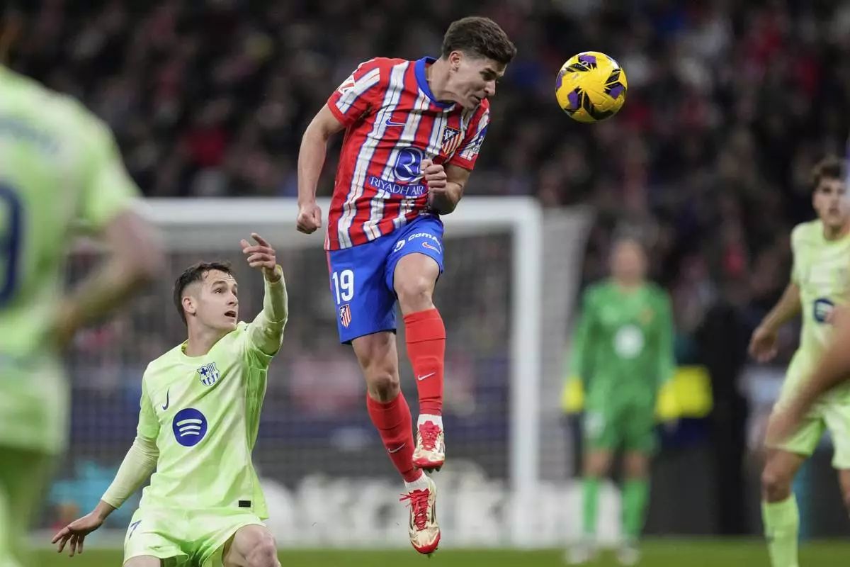 Julian Alvarez rises above Marc Casado.